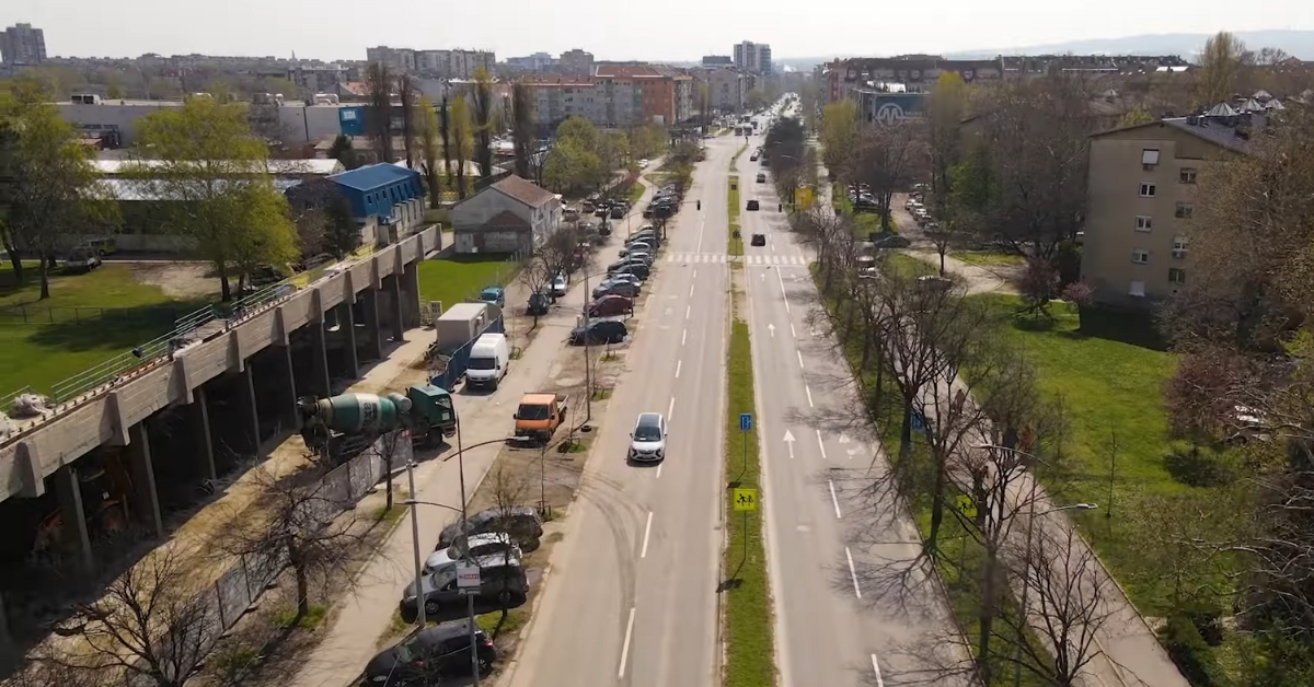 Ulični prizor Detelinare sa širokim bulevarom, parkiranim kolima i drvećem