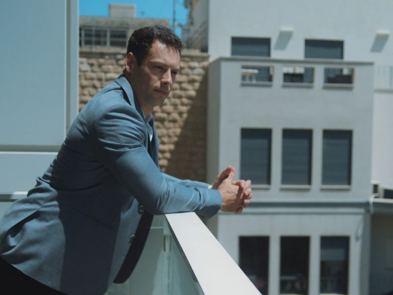 čovek stoji naslonjen na terasu u svom stanu