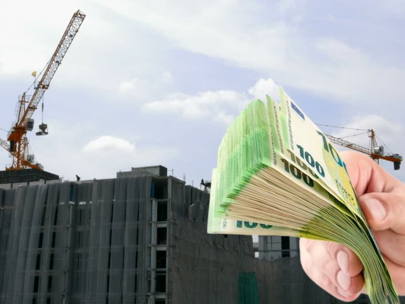 prikaz izgradnje zgrade u novogradnji i uosbe koja drži mnogo novca u ruci